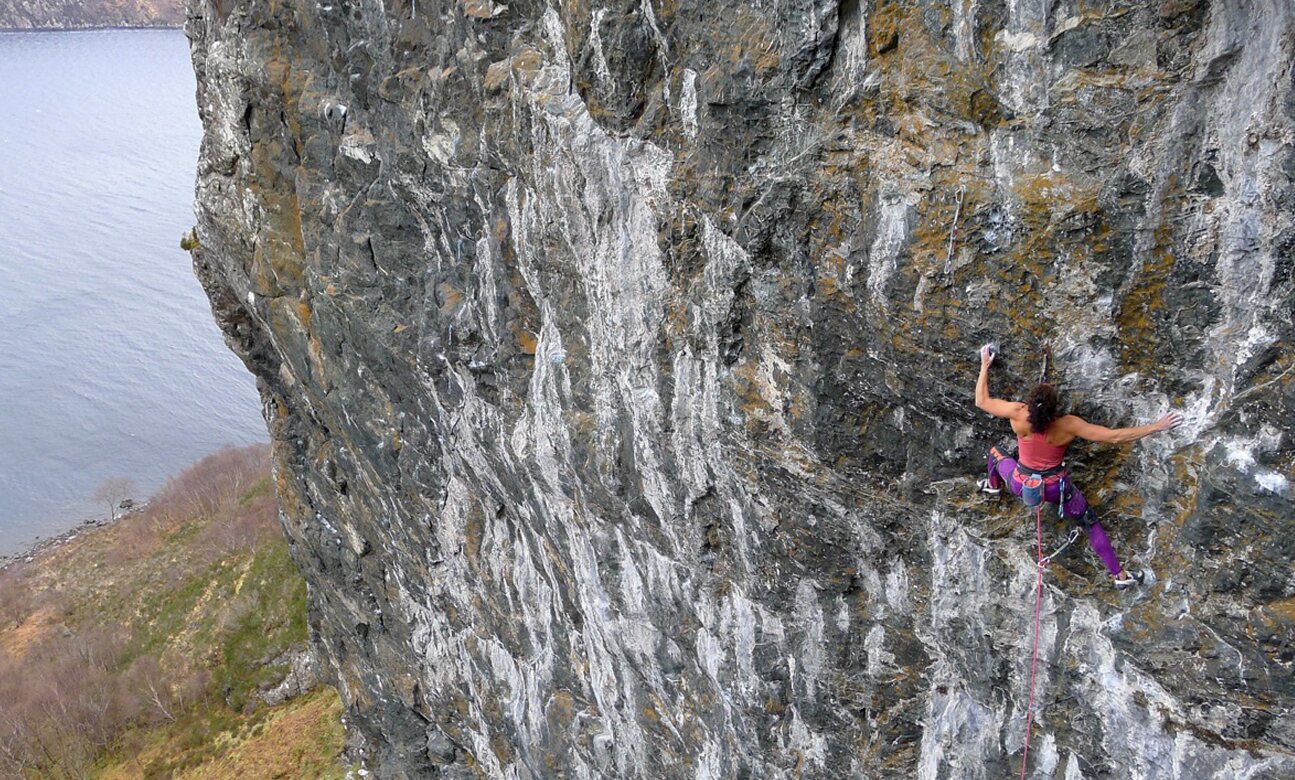 A climber on a steep wall above the loch, Wester Ross